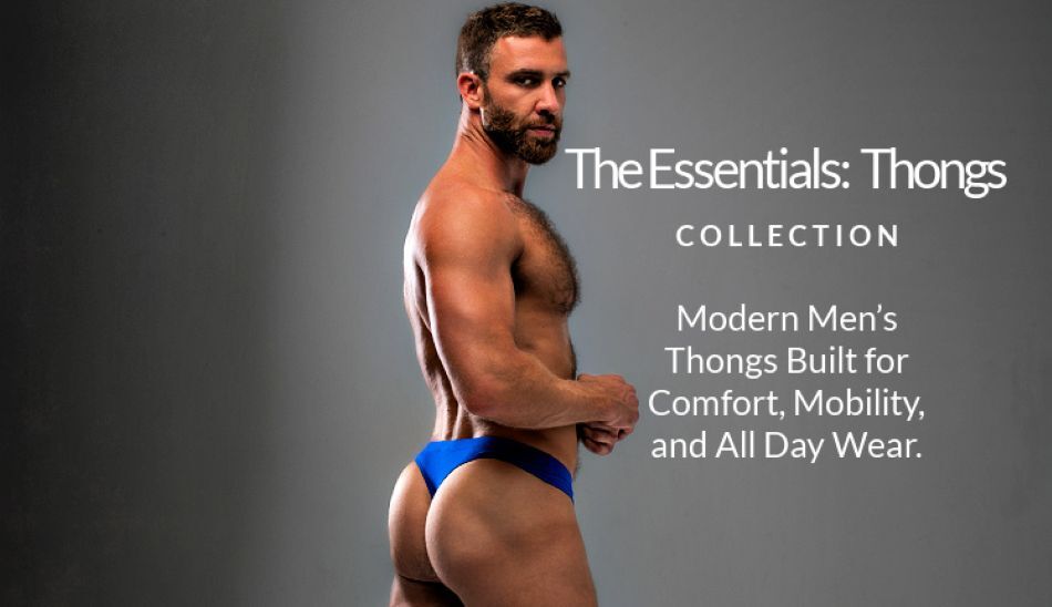 Shirtless man wearing a pair of Jack Adams' international blue Modal Bikini Thong in front of a grey background.