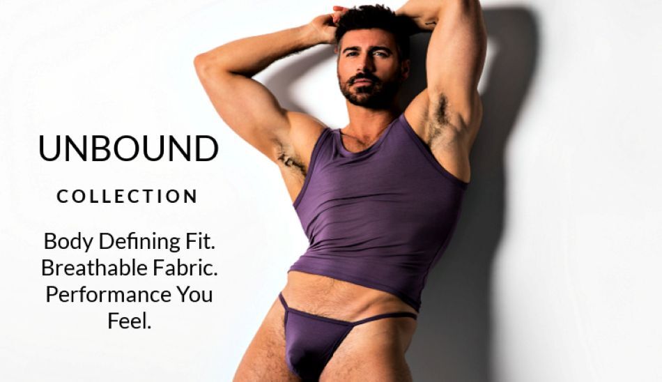 Man standing with his arms above his head wearing  a pair of Jack Adams dusty violet  thong and tank top.