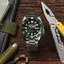 Seiko 5 Sports SKX Series SRPD63K1 con esfera verde y brazalete de acero sobre superficie de madera