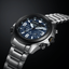 Reloj Citizen Eco Drive Land JV1006-51L con esfera azul y brazalete de acero sobre fondo oscuro