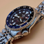 Reloj Seiko 5 Sports SSK003K1 GMT con esfera azul, aguja GMT roja y brazalete de acero en fotografía lifestyle