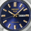 Detalle de la esfera azul del Seiko 5 Sports SRE021K1 con índices dorados y calendario de día y fecha