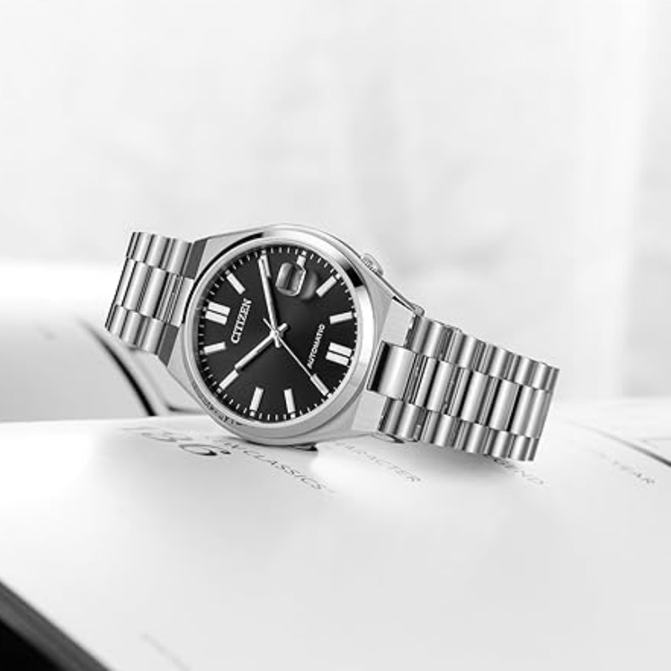 Citizen Tsuyosa NJ0150-81E con esfera negra y brazalete de acero sobre superficie clara