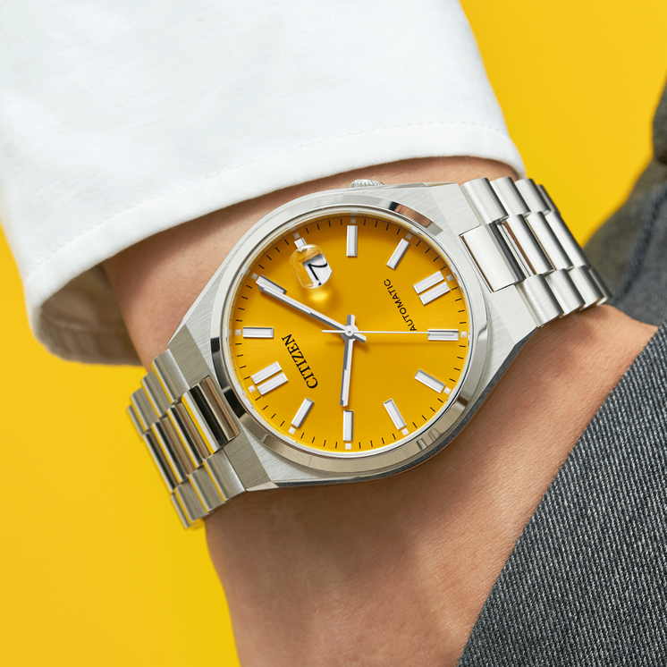 Reloj Citizen Tsuyosa NJ0150-81Z automático con esfera amarilla puesto en la muñeca