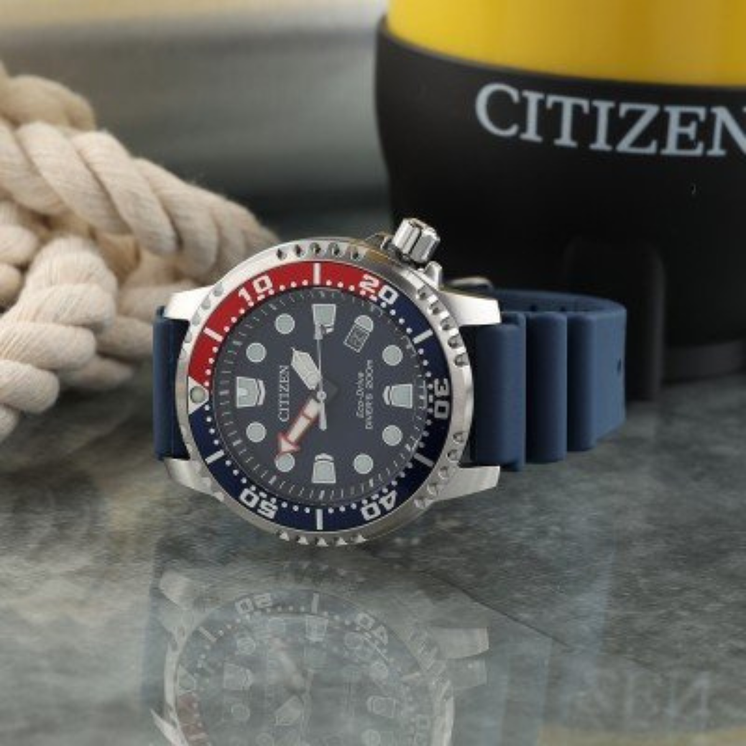 Citizen Diver’s Eco Drive BN0168-06L con esfera azul, bisel rojo y azul y correa de caucho en fotografía lifestyle