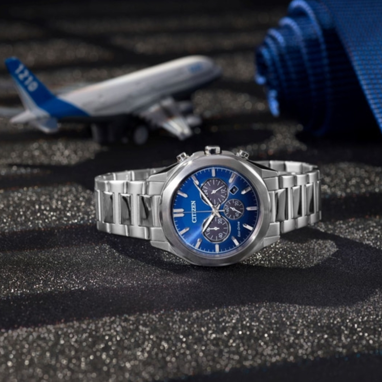 Reloj Citizen Chrono Elegant CA4590-81L con esfera azul y brazalete de acero sobre superficie oscura