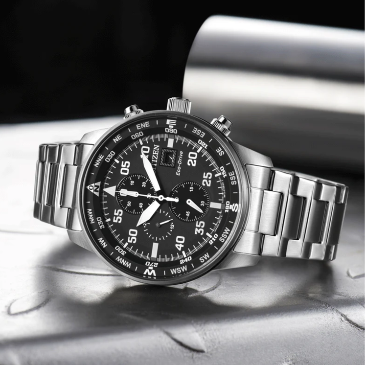 Reloj Citizen Aviator Crono CA0690-88E con esfera negra y brazalete de acero en fotografía lifestyle
