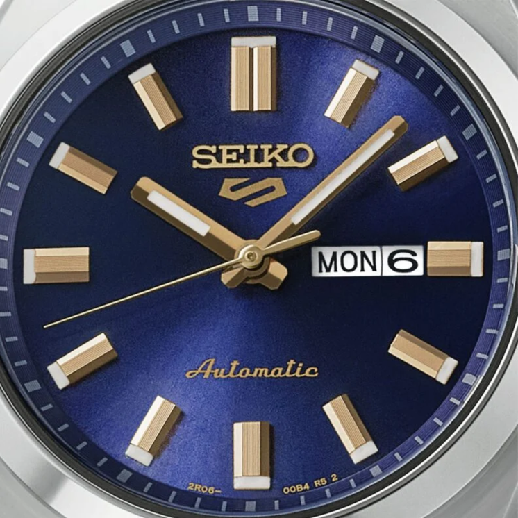 Detalle de la esfera azul del Seiko 5 Sports SRE021K1 con índices dorados y calendario de día y fecha