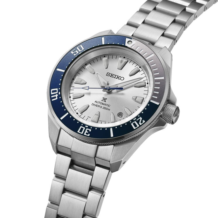Detalle en perspectiva del Seiko Prospex HBB001K1 con esfera plateada, bisel azul y brazalete de acero