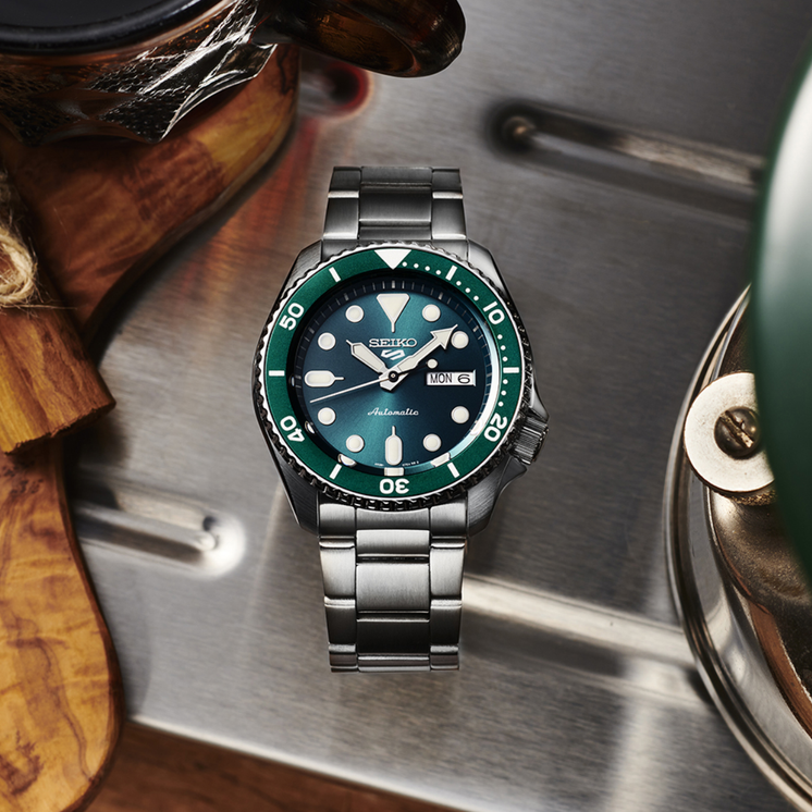 Reloj Seiko 5 Sports SKX Series SRPD61K1 con esfera verde y brazalete de acero inoxidable en fotografía lifestyle
