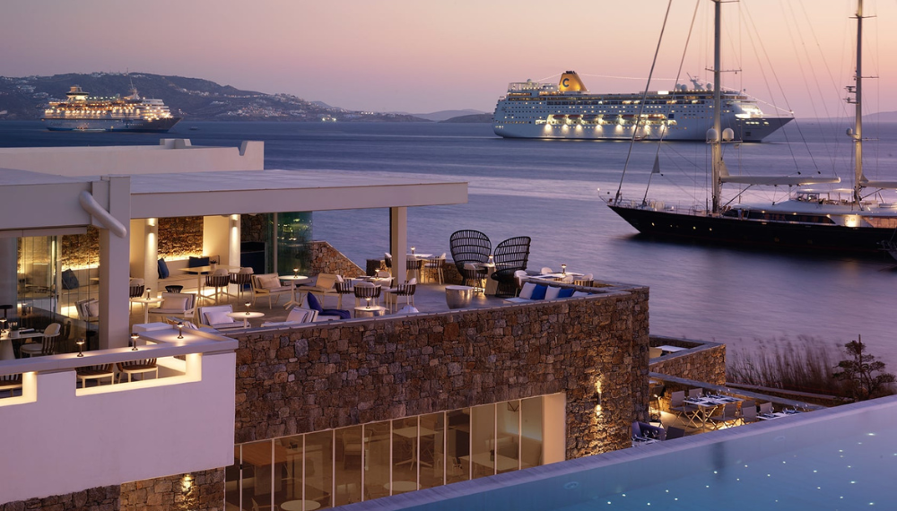 Lounge by the outdoor heated seawater infinity pool with your Mykonos Riviera resort day pass for an unforgettable port day.
