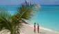 Guests enjoying a private Rose Island beach with the Sip & Sea Resort for a Day pass, sipping tropical cocktails, lounging on beach chairs, and swimming in turquoise waters with snorkeling gear