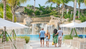 Couple walking through lush tropical foliage at Baha Bay Nassau water park and beach day pass