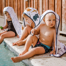 three children beside pool with Little Unicorn hooded muslin toddler towels.jpg