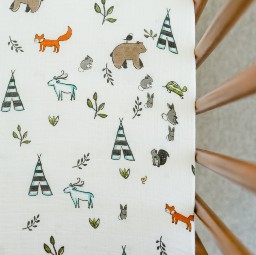 Little Unicorn Muslin Cot Sheet - Forest Friends on a cot mattress.jpg