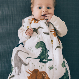 Baby lying awake with fingers in mouth dressed in a Little Unicorn muslin sleeping bag.jpg