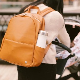 Mum wearing Little Unicorn Skyline Backpack Nappy Bag - Cognac.jpg