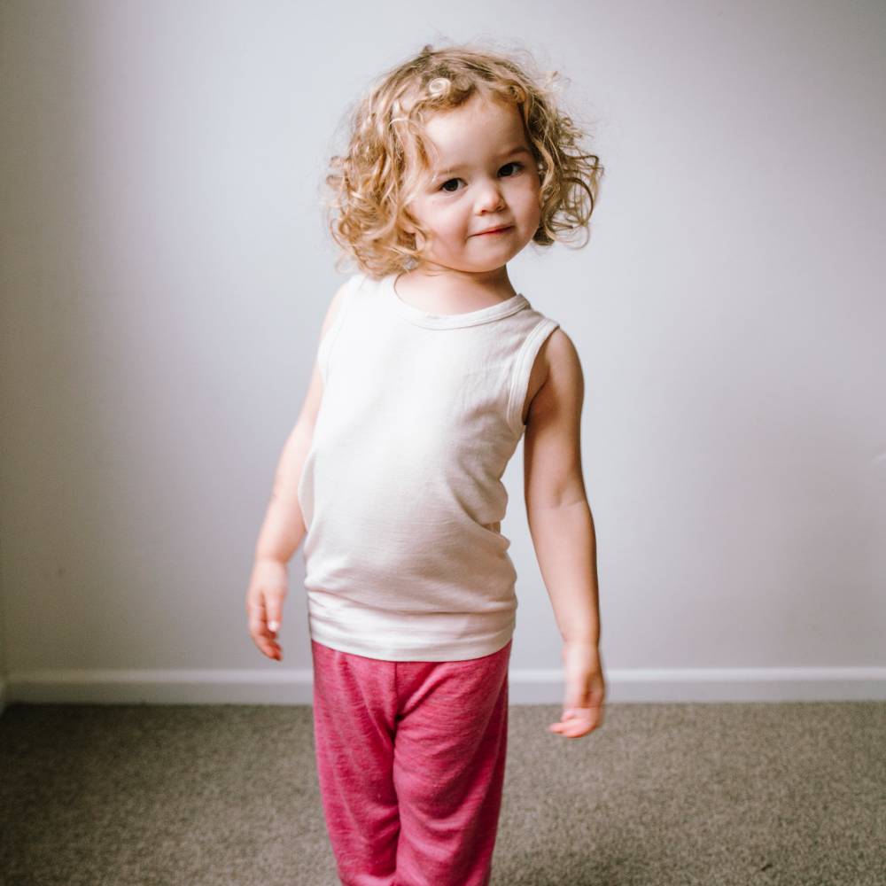 Preschooler wearing All Seasons Merino/Tencel Kids Singlet in Milk and deluxe rib merino leggings