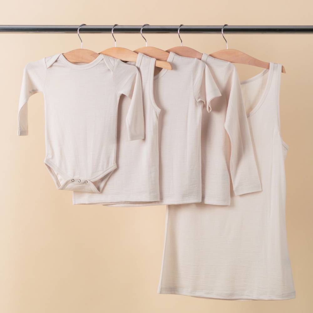 The Sleep Store All Seasons Merino/Tencel range of clothing hanging on a rail - bodysuit, singlet, short sleeve top, long sleeve top and women's singlet