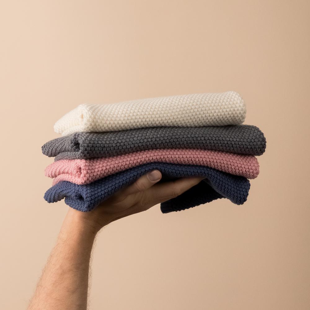 Stack of The Sleep Store Merino Knit Crew Jumpers in natural, grey marle, pink and blue