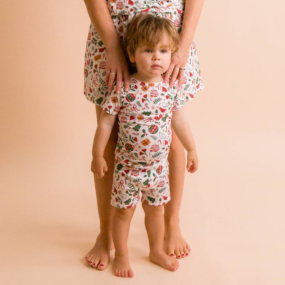 Toddler wearing short sleeve summer pj's with a christmas print