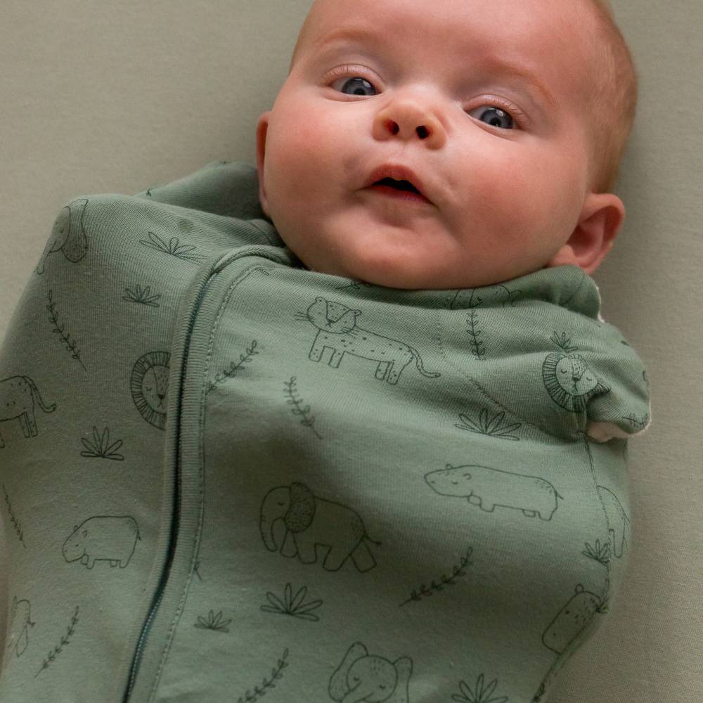 Baby swaddled with arms on chest in the sleep store swaddle bag