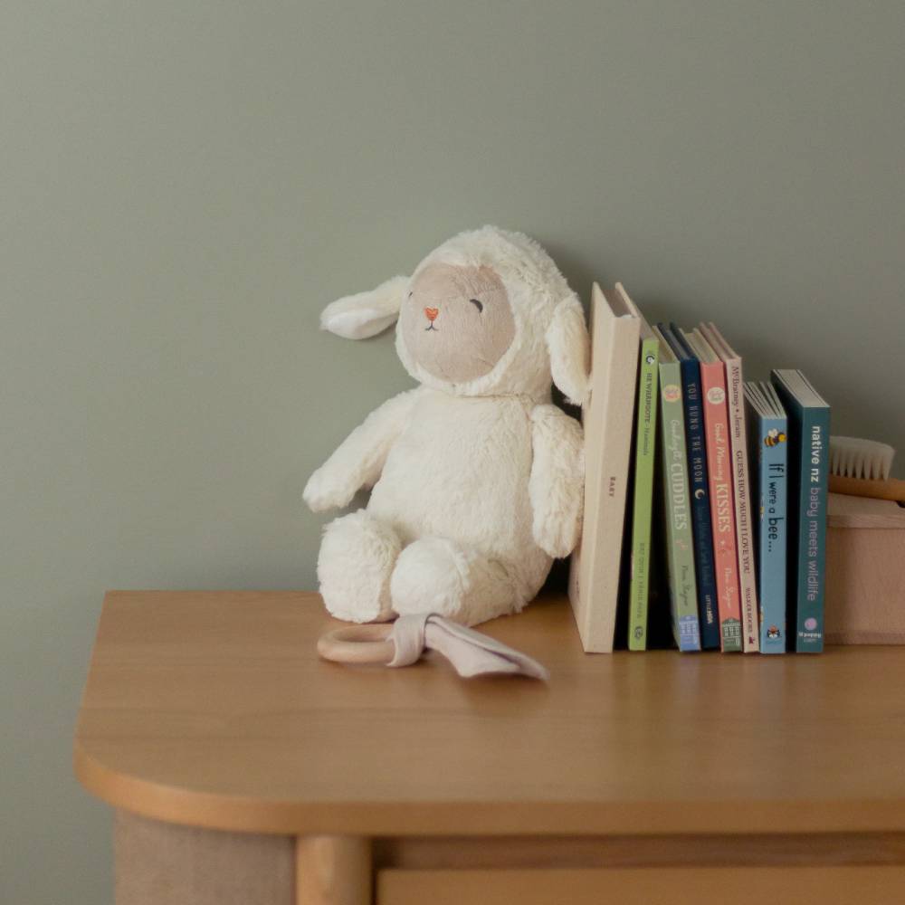 loulou lamb glow friend sitting on a nursery table