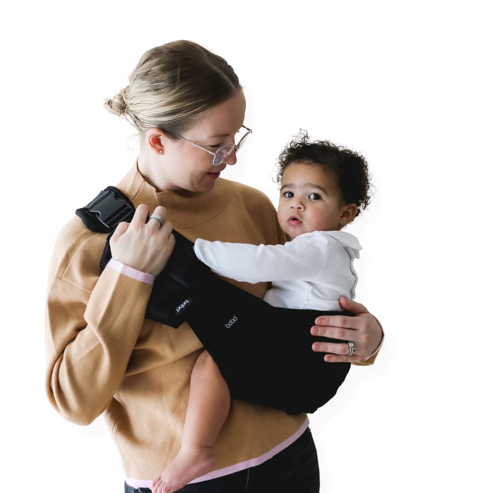 Beco Buddy Toddler Hip Carrier, Woman wearing the black carrier with a toddler.