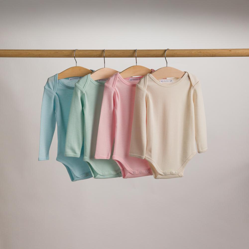 Hanging shot of 4 x Sleep Store Deluxe New Zealand Merino Wool Long Sleeve Bodysuits - from left to right - Soft Sky, Sage, Blush and Ecru.