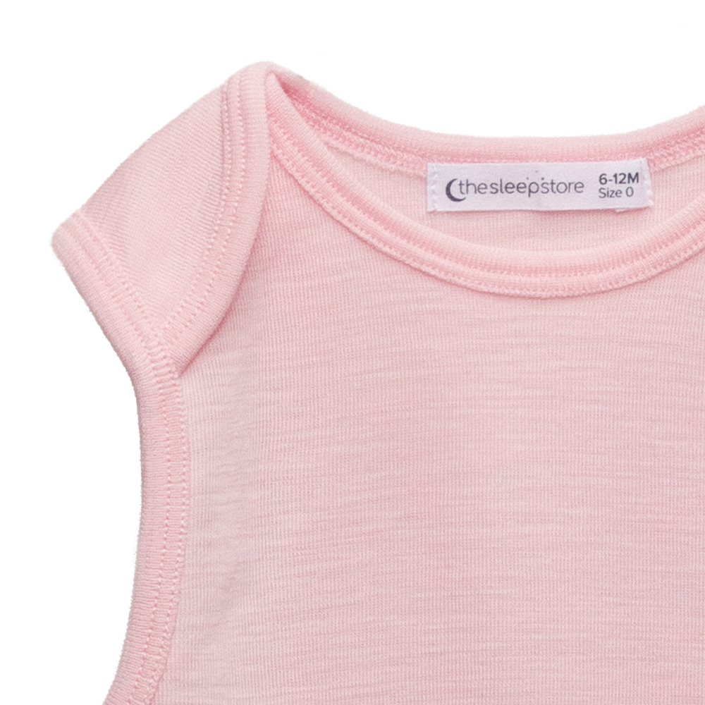 Closeup image of the envelope neckline of the Sleep Store Deluxe New Zealand Merino Wool Singletsuit in the colour Blush.