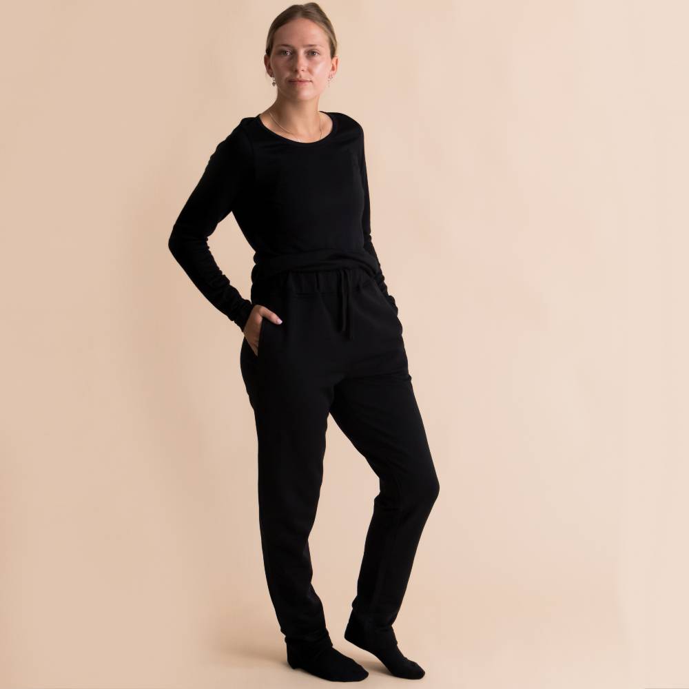 A front shot of a woman wearing The Sleep Store Merino Tencel Fleece Adult Joggers in Black.