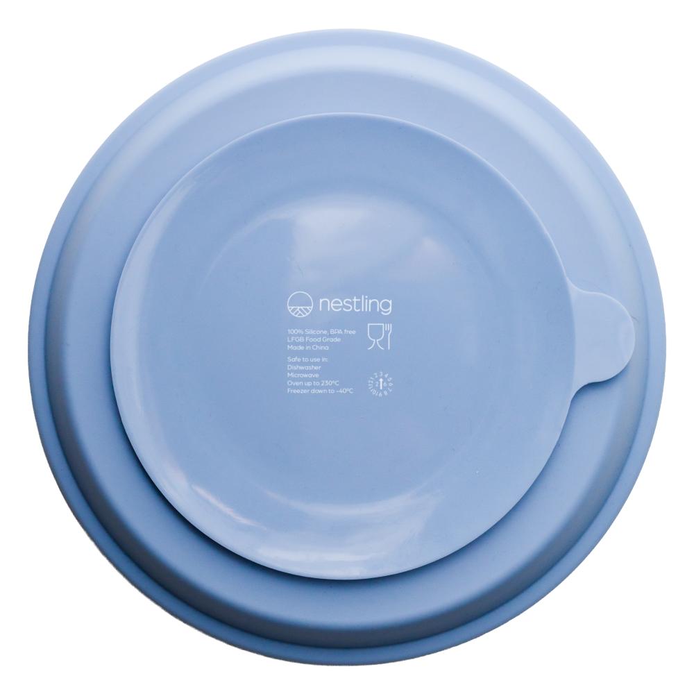 A clearcut image of the Nestling Stainless Steel 23cm Divided Suction Plate in the colour Dusty Blue. This is showing the back/underside of the plate showcasing the suction feature.