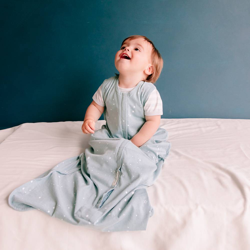 Baby laughing while wearing woolbabe merino/organic cotton summer sleeping bag in tide stars