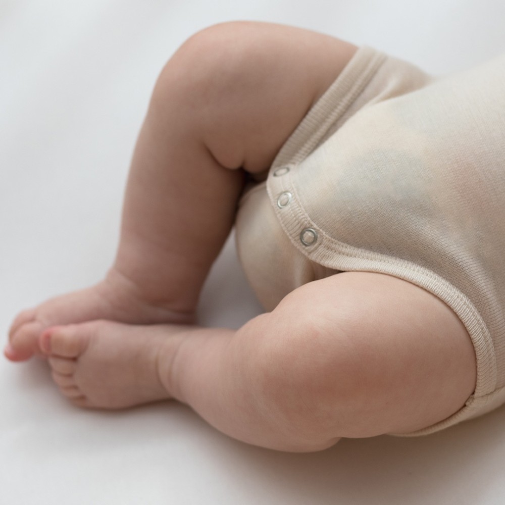 Chubby baby legs showing the reinforced domes on the merino long sleeve bodysuit