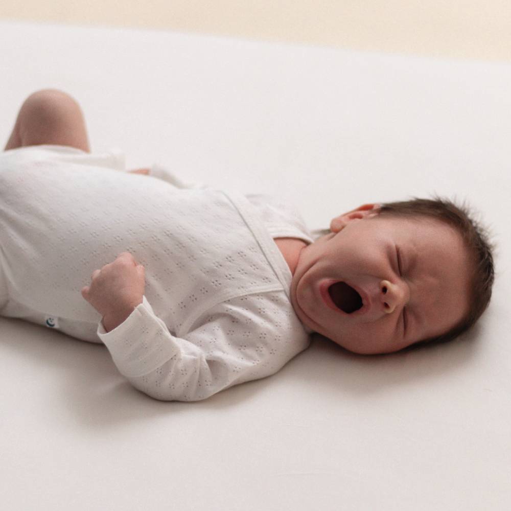 Baby yawning wearing white Organic Cotton Pointelle Kimono Long Sleeve Bodysuit