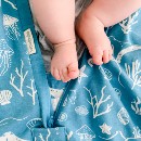 little-baby-feet-over-a-woolbabe-merino-organic-cotton-summer-sleeping-bag-in-aqua-seascape-print.jpg