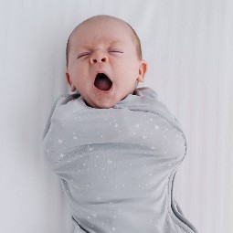 newborn-yawning-while-swaddled-in-the-sleep-store-organic-cotton-swaddle-grey-star.jpg