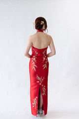 Halter neck red cheongsam gown featuring elegant floral embroidery and asymmetrical neckline. Perfect for tea ceremonies or modern cultural weddings. Available to purchase or hire at Bridal Fusion by Steph in Auckland. Under $2,000, with over 10+ styles to try on.