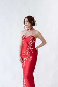 Halter neck red cheongsam gown featuring elegant floral embroidery and asymmetrical neckline. Perfect for tea ceremonies or modern cultural weddings. Available to purchase or hire at Bridal Fusion by Steph in Auckland. Under $2,000, with over 10+ styles to try on.