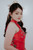 Close-up of hand-embroidered red qipao bodice with pearl and bead floral detail