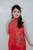 Close-up of hand-embroidered red qipao bodice with pearl and bead floral detail