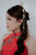 Close-up of hand-embroidered red qipao bodice with pearl and bead floral detail