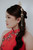 Close-up of hand-embroidered red qipao bodice with pearl and bead floral detail