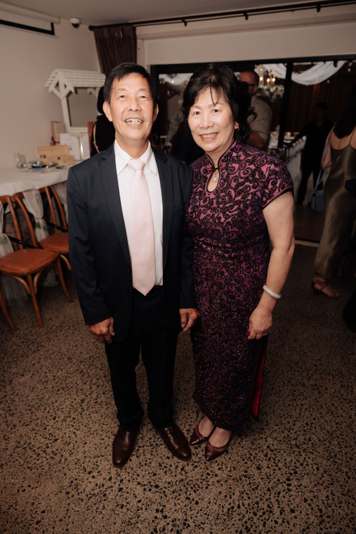 Royal purple cheongsam with all-over black velvet swirl appliqué and gold glitter beading worn at a wedding reception – Bridal Fusion NZ