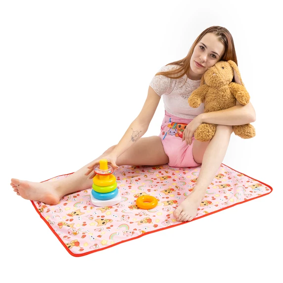 Female model sitting on the absorbent Purrfection change pad with stuffed animal and toys.