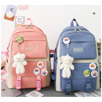 Cute girl travel bags, pink and blue waterproof backpacks with teddy bear keychains and colorful stickers.