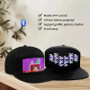 Two black LED Baseball Cap with colorful pixelated designs, USB rechargeable, on a wooden table surface.