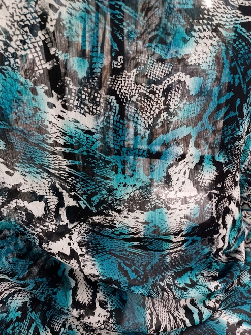 Teal and black snakeskin print Yoryu crinkle chiffon fabric showing sheer texture and vertical pleats.