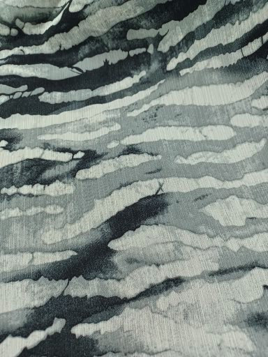 Detailed view of 100% polyester Yoryu chiffon featuring a washed watercolor zebra print in black and white with subtle, cool smoky-grey undertones and a vertical crinkle texture.