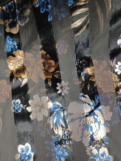 A macro shot of Midnight Floral Devoré fabric, showing detailed blue and bronze botanical velvet patterns burnout on black sheer mesh stripes with rich, enhanced colors.